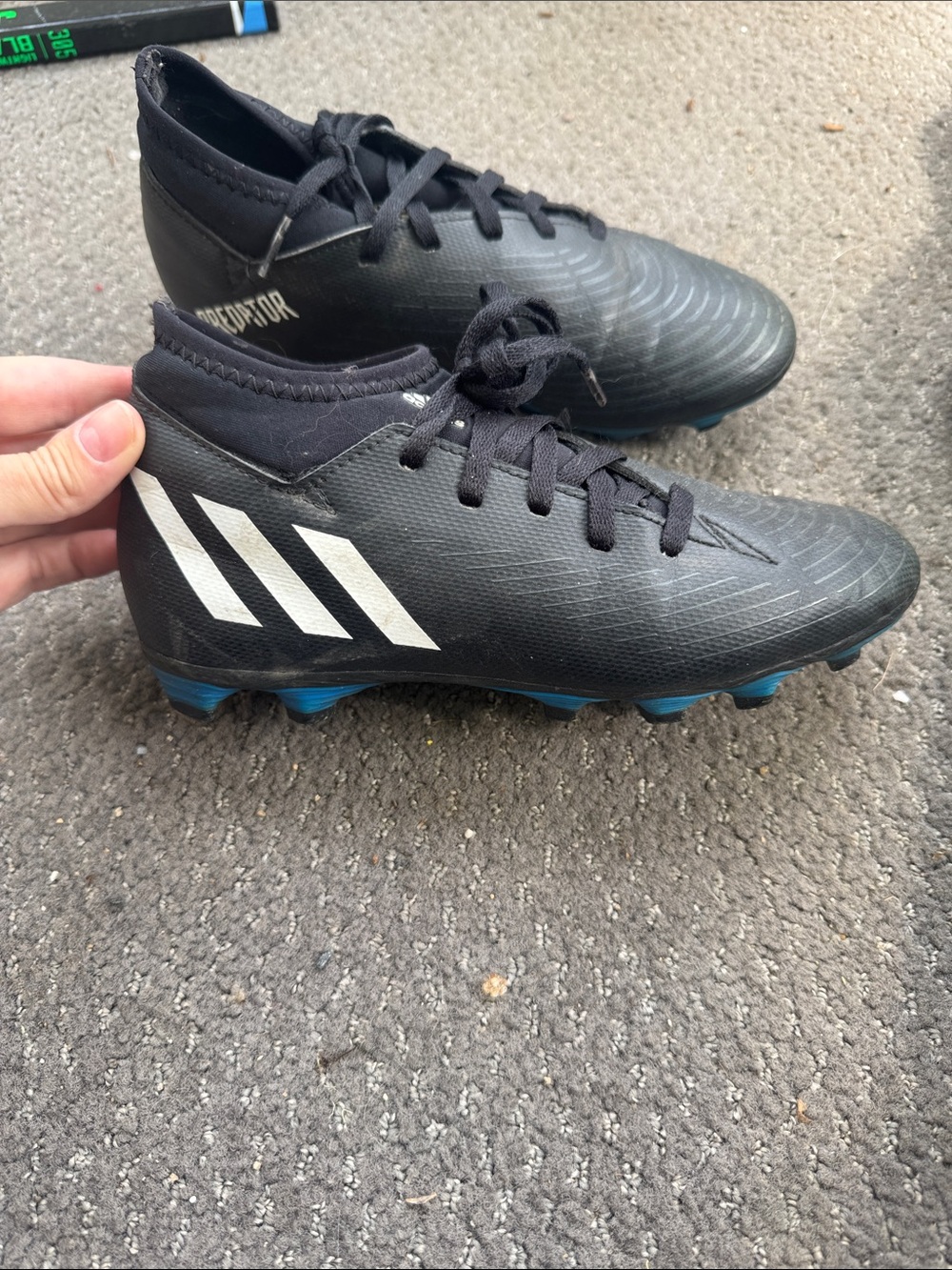 Boys adidas Black Soccer Cleats with White Stripes and Blue bottoms